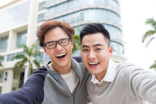 Two Vietnamese men traveler taking selfie in foreign city