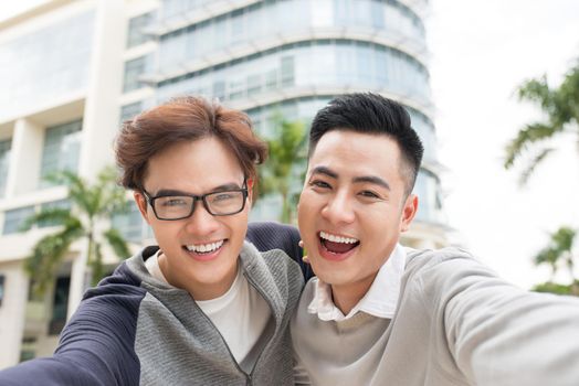 Two Vietnamese men traveler taking selfie in foreign city