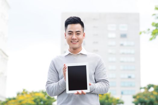 Young Business man holding and showing the screen of tablet