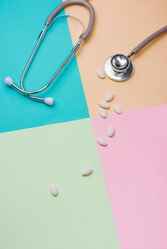 Medical concept. The stethoscope and pills on colorful background.