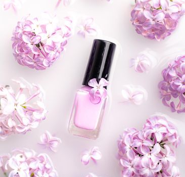 Lilac nail polish and a branch of lilac . A bottle of nail polish without a name. The concept of advertising the products of lacquers . Beauty and fashion. Nail care. Spring