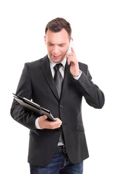 Portrait of a young fashionable businessman, looking at a clipboard and talking on a mobile phone, looking worried, pensive, stressed, serious, anxious, isolated on white background.