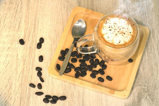 Hot brewed coffee with frothed milk on a wooden tray lined with fresh coffee beans on the table The idea of ​​refreshing coffee in the morning.