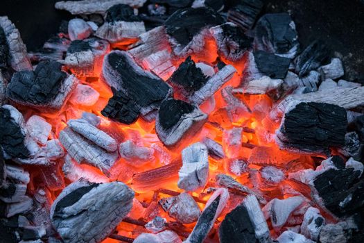 A closeup of glowing and flaming pieces of coal. Ready to start a barbecue.