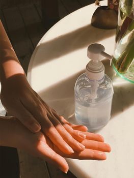 Hand of woman pressing alcohol gel from bottle and applying sanitizer gel for hand wash to make cleaning and clear germ