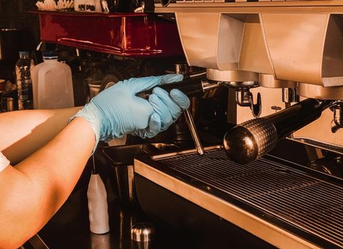 Barista holding portafilter making espresso coffee at the cafe at the coffee machine. Coronavirus situation