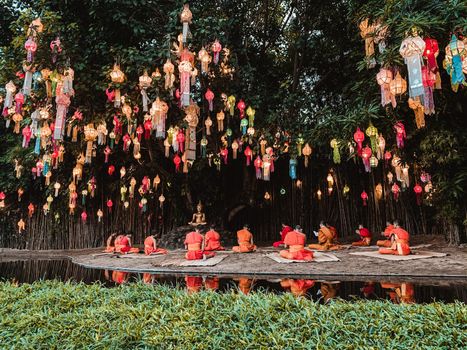 Buddhist monks sit meditating Under the light of the Beautiful lantern of paper annually at Wat Pan Tao temple.