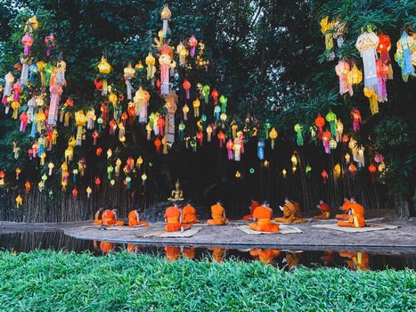 Buddhist monks sit meditating Under the light of the Beautiful lantern of paper annually at Wat Pan Tao temple.