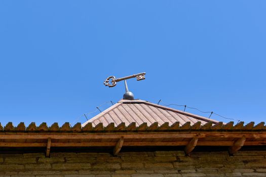 Key symbol of the city on the roof of the fortress tower against the blue sky