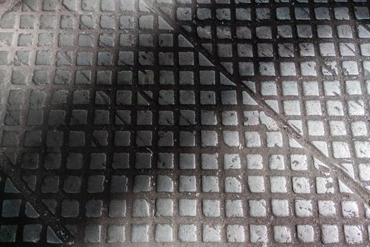 old cast iron industrial floor tiles with checkered skid-proof pattern - factory background.