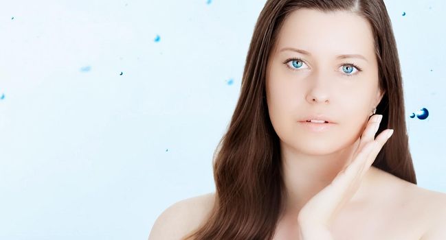 Rejuvenation skincare and beauty ad, beauty face portrait of young woman with healthy clean skin, blue cosmetic liquid drops on background.