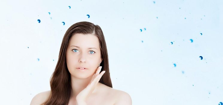 Rejuvenation skincare and beauty ad, beauty face portrait of young woman with healthy clean skin, blue cosmetic liquid drops on background.