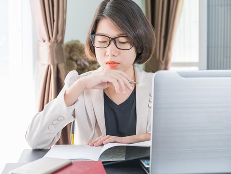 Teenage girl short hair in smart casual wear working on laptop while sit near window in home office