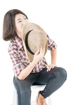 Young pretty woman in a cowboy hat and plaid shirt posing in studio with isolated on white background