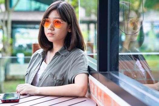 Pretty woman sitting in a cafe terrace use smartphone