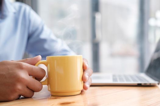 Men hand holding hot cup of coffee or tea. Relax take a coffee break.