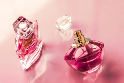 Perfumery, spa and branding concept - Pink perfume bottle on glossy background, sweet floral scent, glamour fragrance and eau de parfum as holiday gift and luxury beauty cosmetics brand design