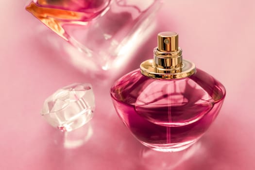 Perfumery, spa and branding concept - Pink perfume bottle on glossy background, sweet floral scent, glamour fragrance and eau de parfum as holiday gift and luxury beauty cosmetics brand design