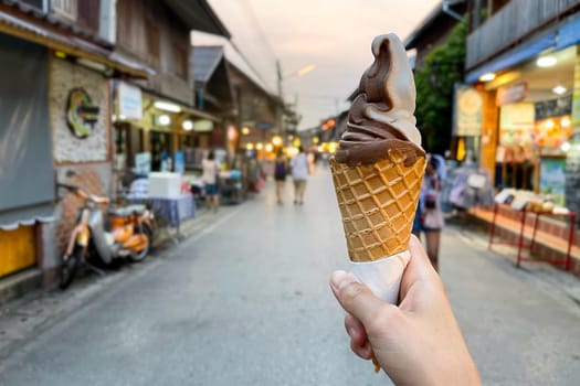 Female hand holding chocolate ice cream