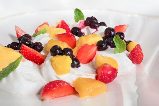 Restaurant dessert served on plate. White Whipped Meringue Cream with fruit. Healthy organic breakfast. Summer breakfast dessert with fresh fruits on ice cream or yogurt healthy diet food vitamin-rich