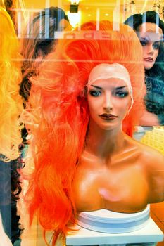 Showcase in store with colorful wigs for drag queens