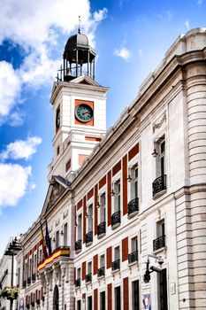 Beautiful perspective of the clock tower of the main square in Madrid called Puerta del Sol in a sunny day