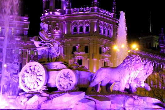 Beautiful City Hall of Madrid and Cibeles fountain illuminated in purple in the International Women's Day