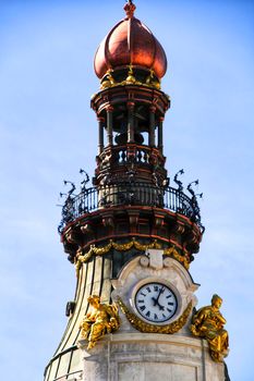 Beautiful and majestic facade with golden cupola and vintage clock in Madrid in a sunny day