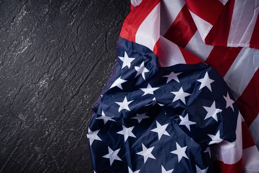 Concept of U.S Independence day or Memorial day. National flag over dark slate table background.