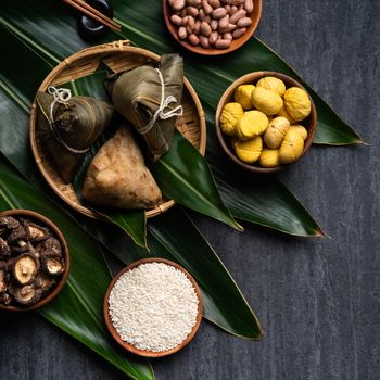 Zongzi. Rice dumpling top view design concept for Chinese traditional Dragon Boat Festival (Duanwu Festival) over dark black slate background.