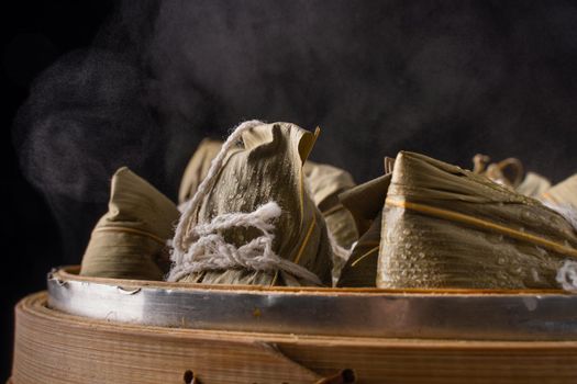 Zongzi. Rice dumpling for Chinese traditional Dragon Boat Festival (Duanwu Festival) on dark wooden table background.