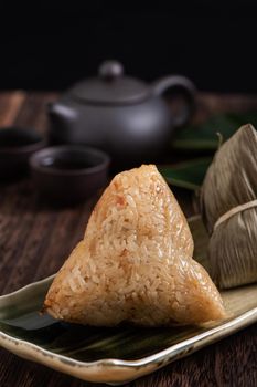 Zongzi. Rice dumpling for Chinese traditional Dragon Boat Festival (Duanwu Festival) on dark wooden table background.