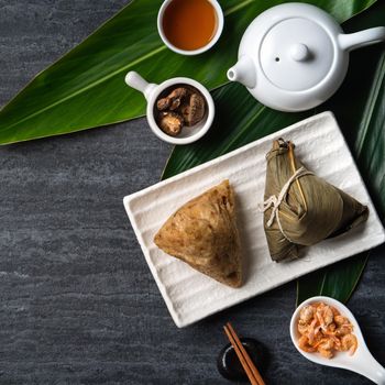 Zongzi. Rice dumpling top view design concept for Chinese traditional Dragon Boat Festival (Duanwu Festival) over dark black slate background.