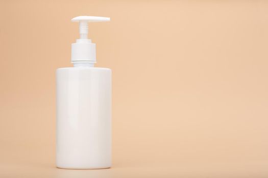 Shower gel, liquid soap or intimate gel in white unbranded tube against light beige background with copy space. Concept of intimate hygiene or gel for sensitive skin