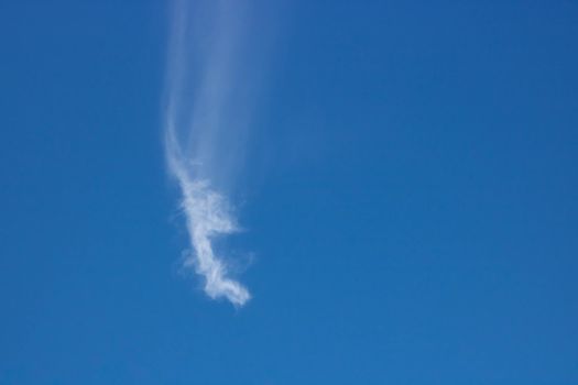 Blue, beautiful sky background. Oddly shaped clouds in a blue sky.