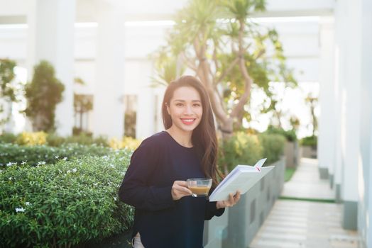 Young and pretty girl reading book on park in sunny day.