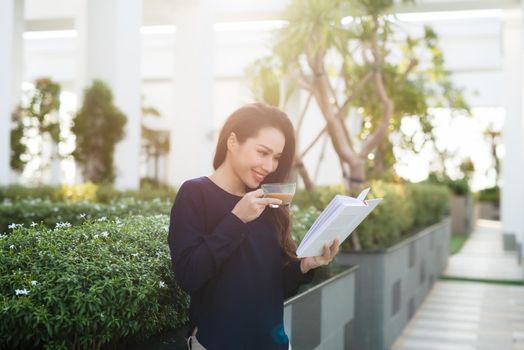 Young and pretty girl reading book on park in sunny day.