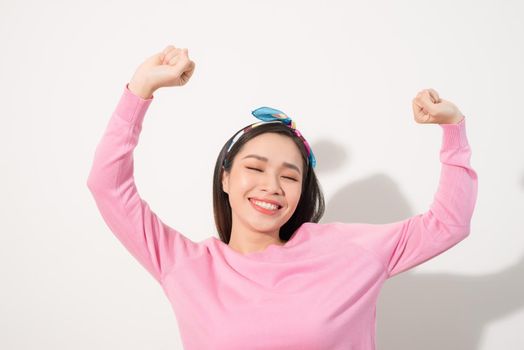 Attractive young woman relax and dance on copy space. Portrait of happy girl dancing your hands up on white background