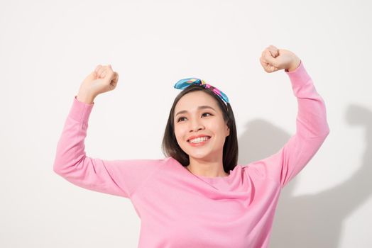 Attractive young woman relax and dance on copy space. Portrait of happy girl dancing your hands up on white background