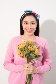 Toothy smiling happy woman holding flower . White background isolated portrait.