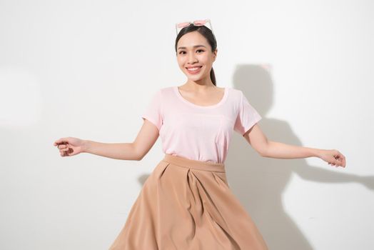 Magnificent girl dancing with smile in white studio. Indoor portrait of inspired caucasian lady in romantic outfit expressing happy emotions.