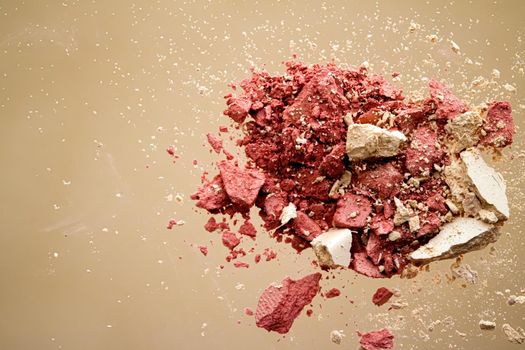 Crushed cosmetics, mineral organic eyeshadow, blush and cosmetic powder isolated on golden background, makeup and beauty banner, flatlay design.