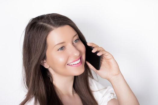 Happy smiling woman calling on smartphone, portrait on white background. People, technology and communication concept.