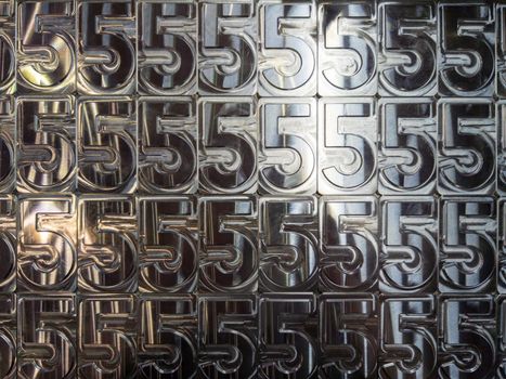 shiny metal machined digit 5 plates tiled tightly - close-up full frame background