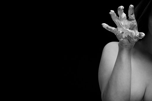 Mud treatment mask for body care. Young nude woman covered in healing clay. Black and white image.