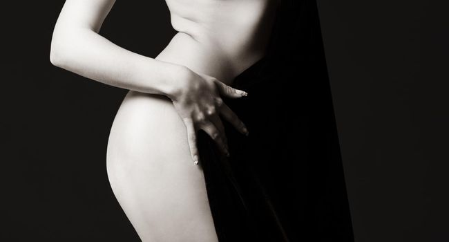 Elegant woman and beauty concept. Half-naked woman posing in the studio. View from the back