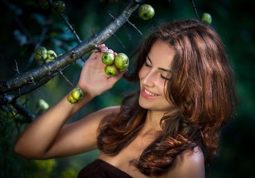 Soft portrait of young woman with wild apples