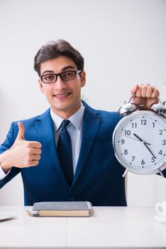 Businessman employee in urgency and deadline concept with alarm clock