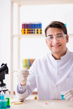 Young chemist student working in lab on chemicals