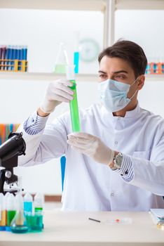 Young chemist student working in lab on chemicals